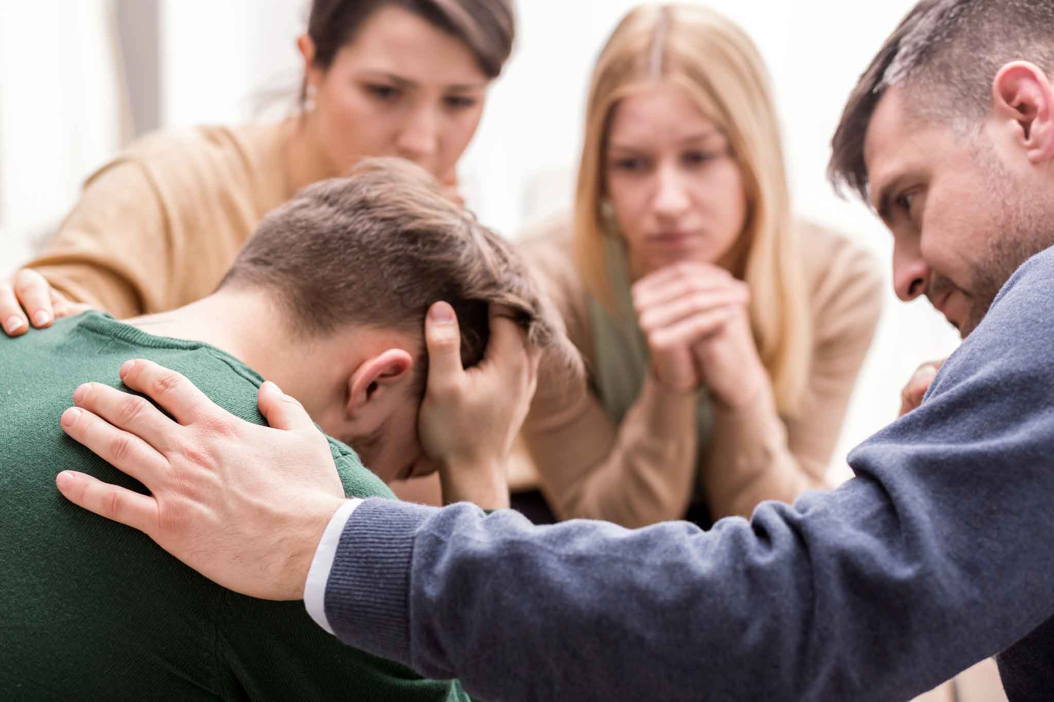 Photo of a family gathering around their son during an intervention.