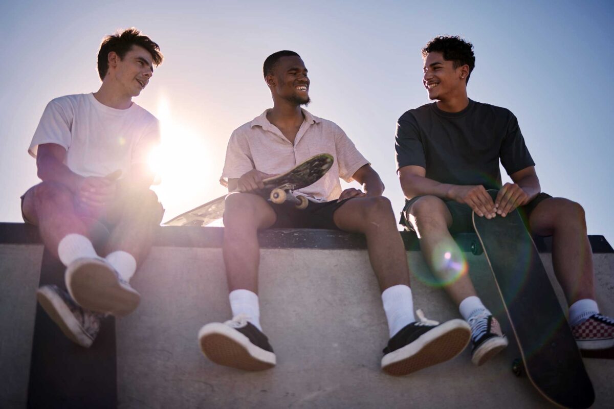 three young men sitting with skateboards building healthy activities and interests in transitional living