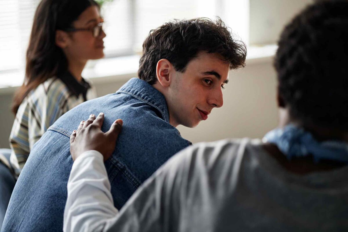 young man in sober living receiving peer support for addiction